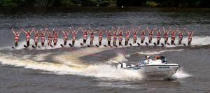 Ballet girls dance on the water while holding the rope in-between their legs.