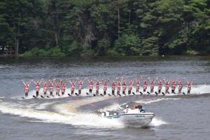 Ballet girls dance on the water while holding the rope in-between their legs.